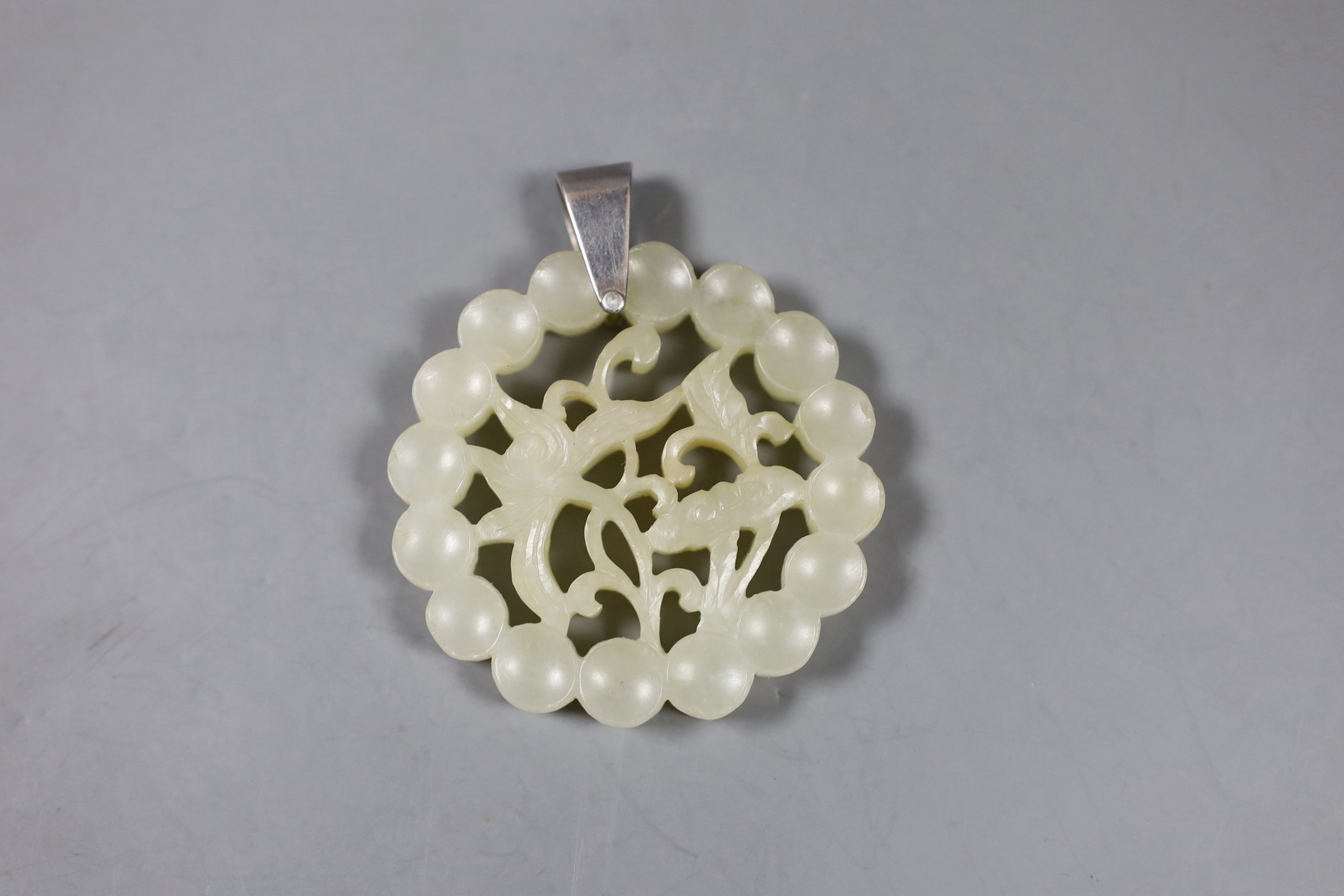 A Chinese carved circular jade pendant. 5.5cm diameter